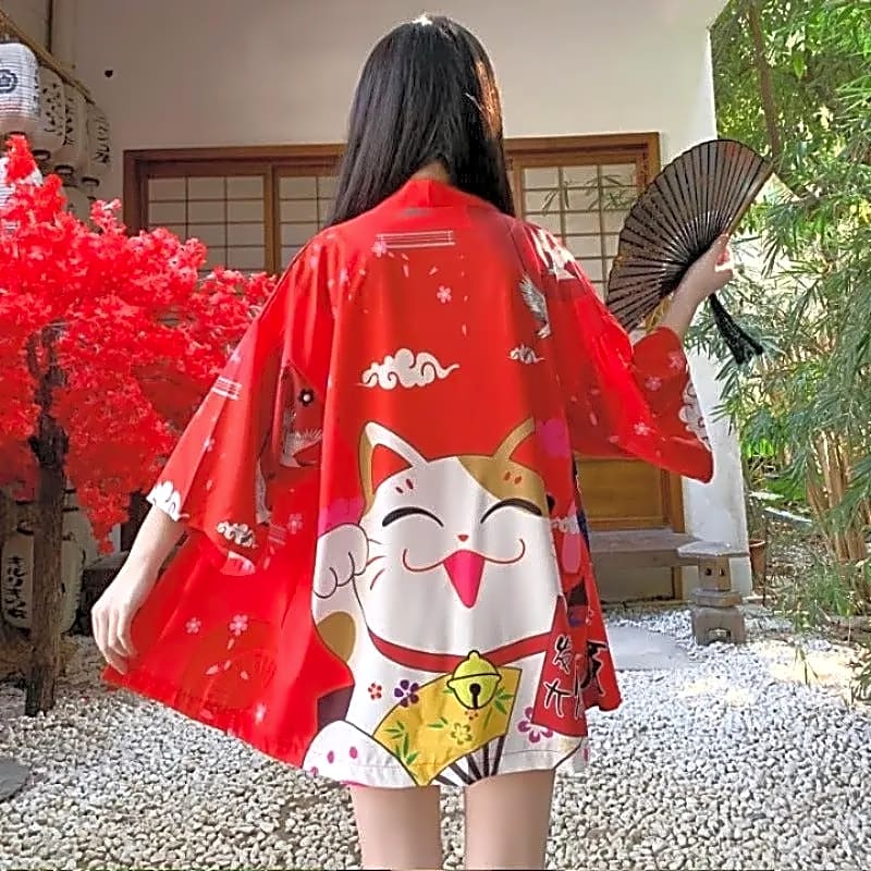 Damskie czerwone haori w japońskim stylu z kotem Maneki-neko i żurawiami, prezentowane w ogrodzie, widok z tyłu na wzór.