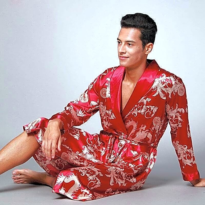 Męski szlafrok kimono z satyny w kolorze czerwonym z orientalnym wzorem smoka, widok z boku w pozycji siedzącej, podkreślający komfort.
