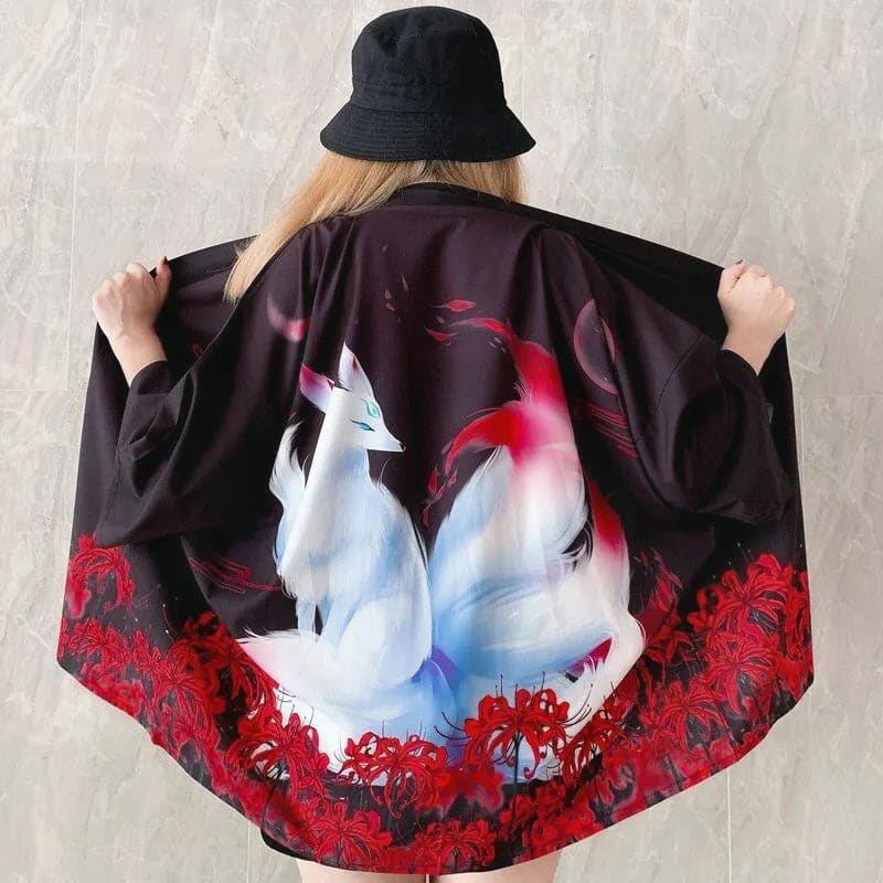 Czarne japonskie haori damskie z lisem kitsune i czerwonymi kwiatami higanbana na plecach, noszone przez kobiete, prezentujace luźny kroj i szerokie rekawy.
