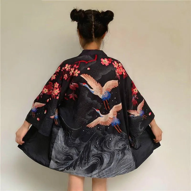 Czarne japońskie kimono haori damskie, widok z tyłu, z eleganckim wzorem lecących żurawi i różowych kwiatów wiśni.