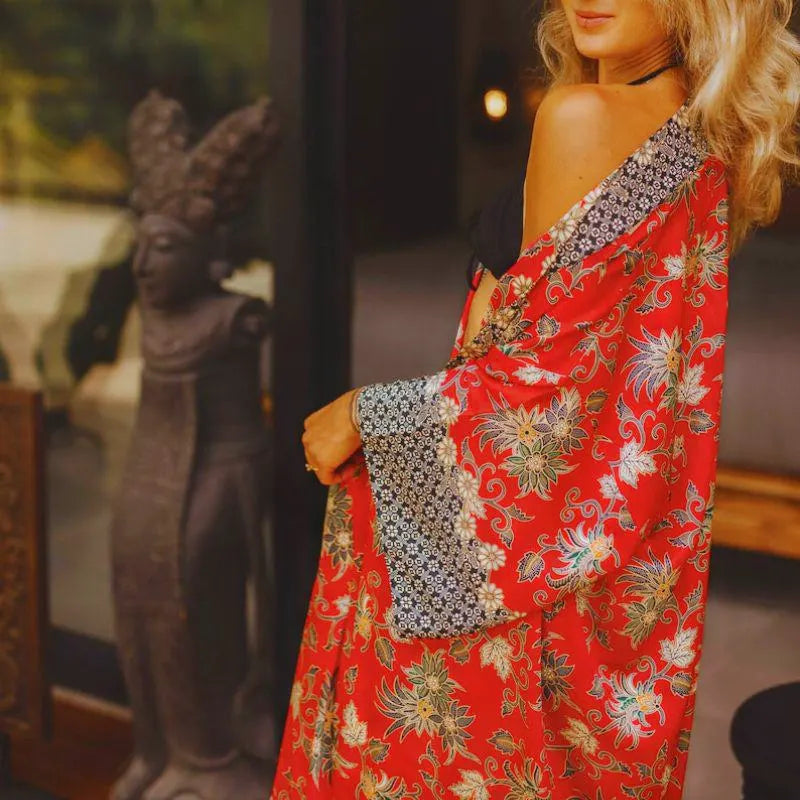 Zbliżenie na czerwone kimono z indyjskiego jedwabiu, ukazujące orientalne kwiatowe wzory i detal rękawa.