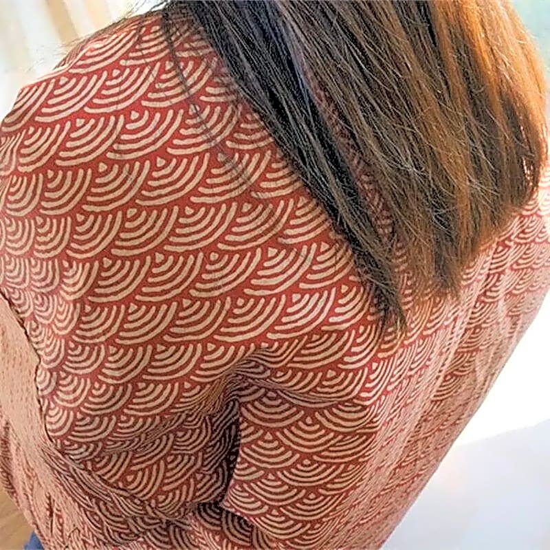 Zbliżenie na tył pikowanej kurtki kimono damskiej, ukazujące szczegółowy czerwony japoński wzór fali seigaiha.