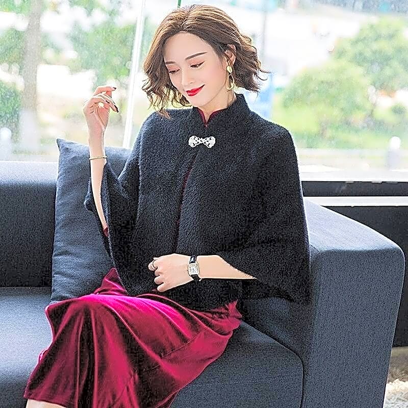 Elegancka krótka pelerynka damska w stylu kimono z imitacji wełny, prezentowana z przodu z ozdobnym zapięciem, idealna na wieczorne wyjścia.