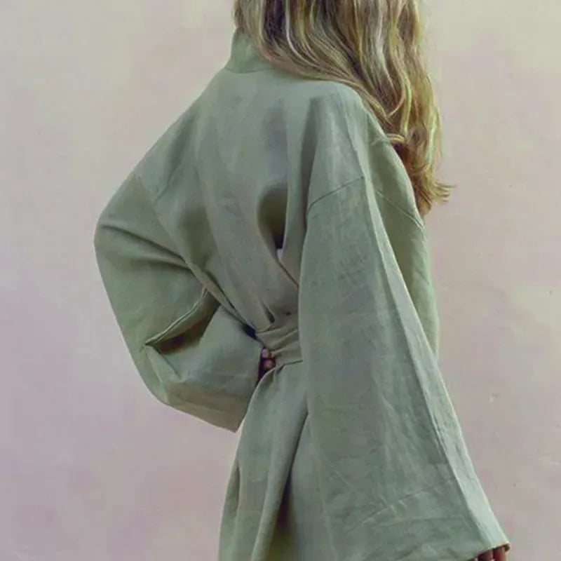 Widok z tyłu na krótkie lniane kimono damskie khaki, podkreślające szerokie rękawy i wiązanie w pasie.