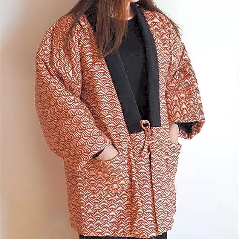 Elegancka pikowana kurtka kimono damska z japońskim wzorem fali seigaiha, widok z przodu z rękami w kieszeniach, doskonała na chłodne dni.