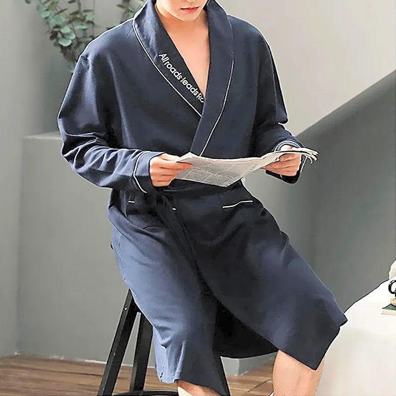 Męski szlafrok bawełniany w stylu kimono, granatowy z elegancką białą lamówką, podczas czytania gazety.
