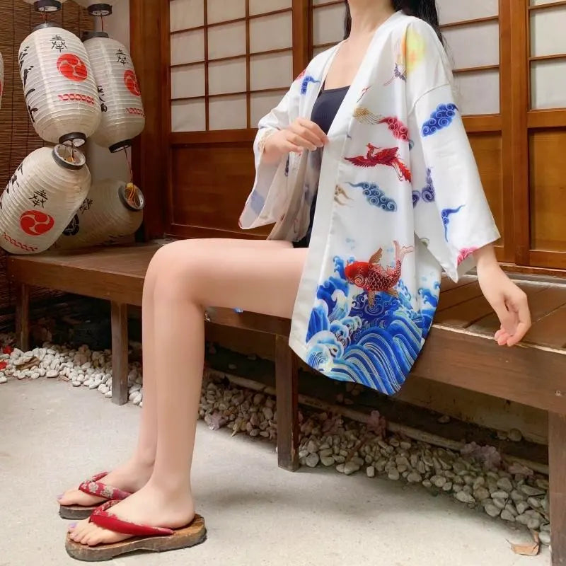 Modelka w białej narzutce kimono vintage z motywem żurawi i fal, siedząca
