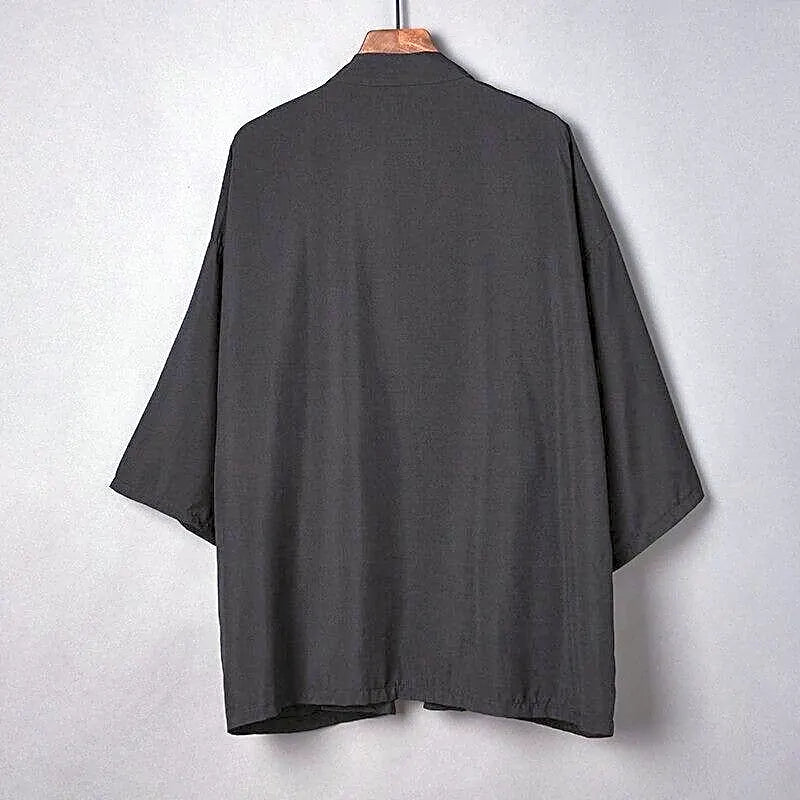 Elegancka czarna narzutka kimono damska, widok z tyłu, z szerokimi rękawami, na wieszaku, uniwersalny dodatek.