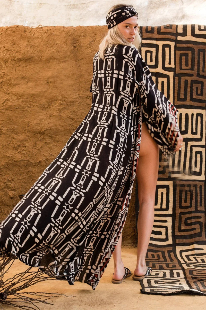 Elegancka narzutka kimono z etnicznym wzorem, wysokim rozcięciem i szerokimi rękawami, idealna jako pareo lub letnia sukienka.