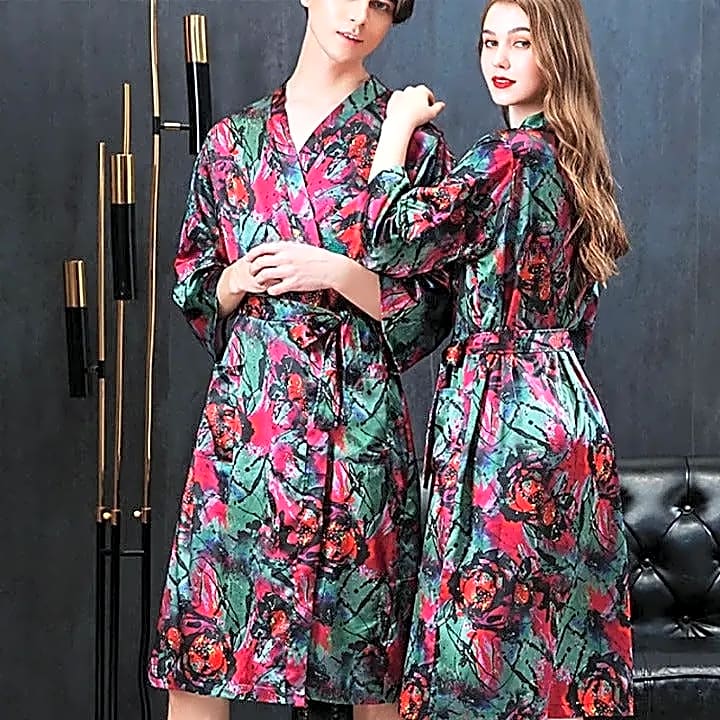 Para w pasujących satynowych szlafrokach kimono z artystycznym wzorem czerwonych kwiatów na zielonym tle, prezentująca unikalny design i komfort.
