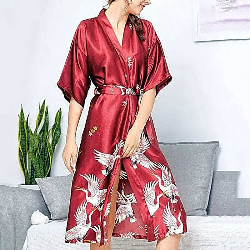 Damski szlafrok kimono w kolorze czerwonym z satyny, ozdobiony wzorem w japońskie żurawie, widok z przodu.