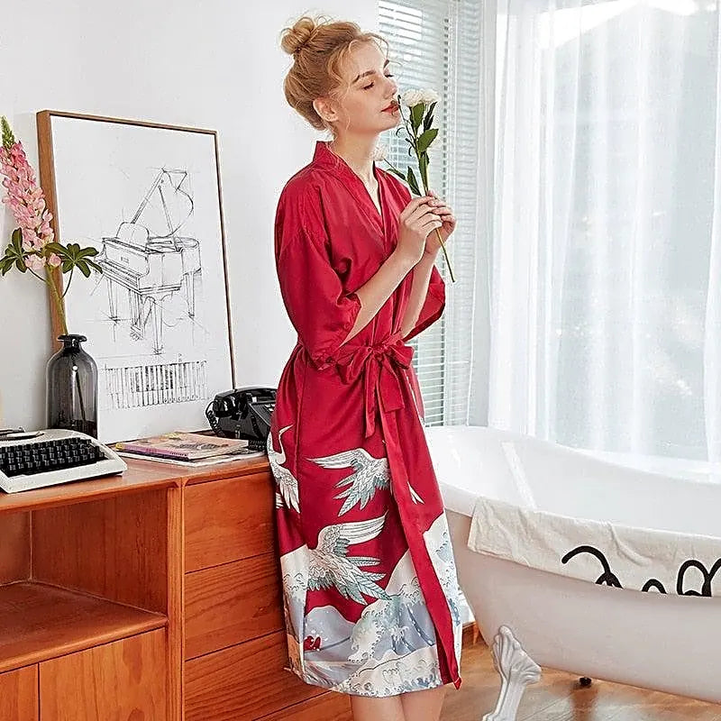 Elegancki damski szlafrok kimono w kolorze bordowym z japońskim wzorem żurawi i fal, noszony przez modelkę w łazience.