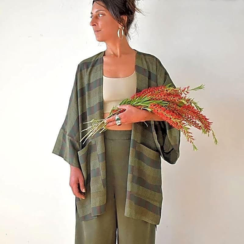 Modelka w zielonym płaszczu kimono z wiskozy bawełnianej, z bukietem kwiatów, ukazująca swobodny styl i wzór w paski.